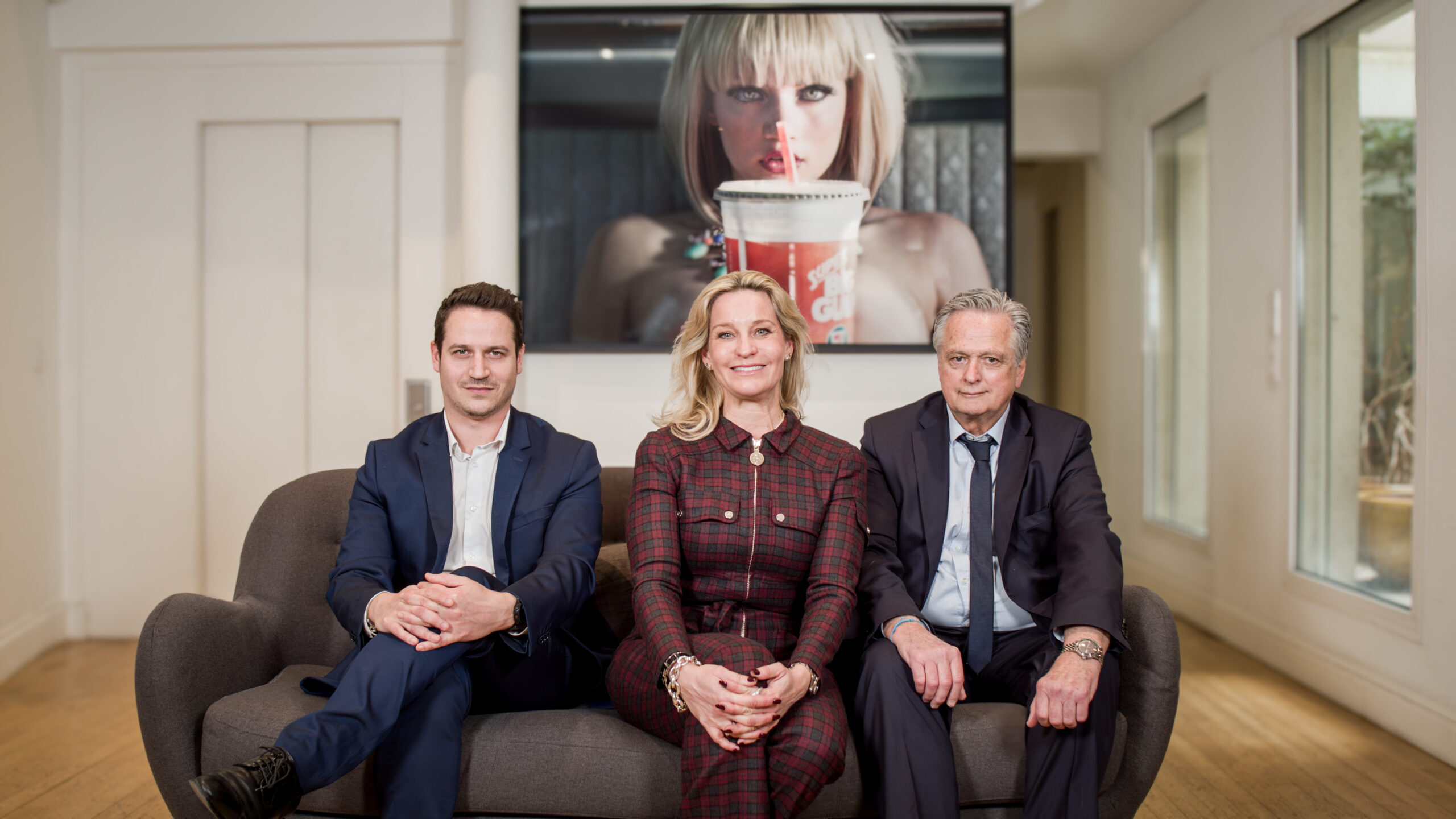Portrait de l’équipe dirigeante de Dynamis Avocats Portrait professionnel de trois membres de l’équipe de direction, assis sur un canapé dans un cadre moderne et élégant.