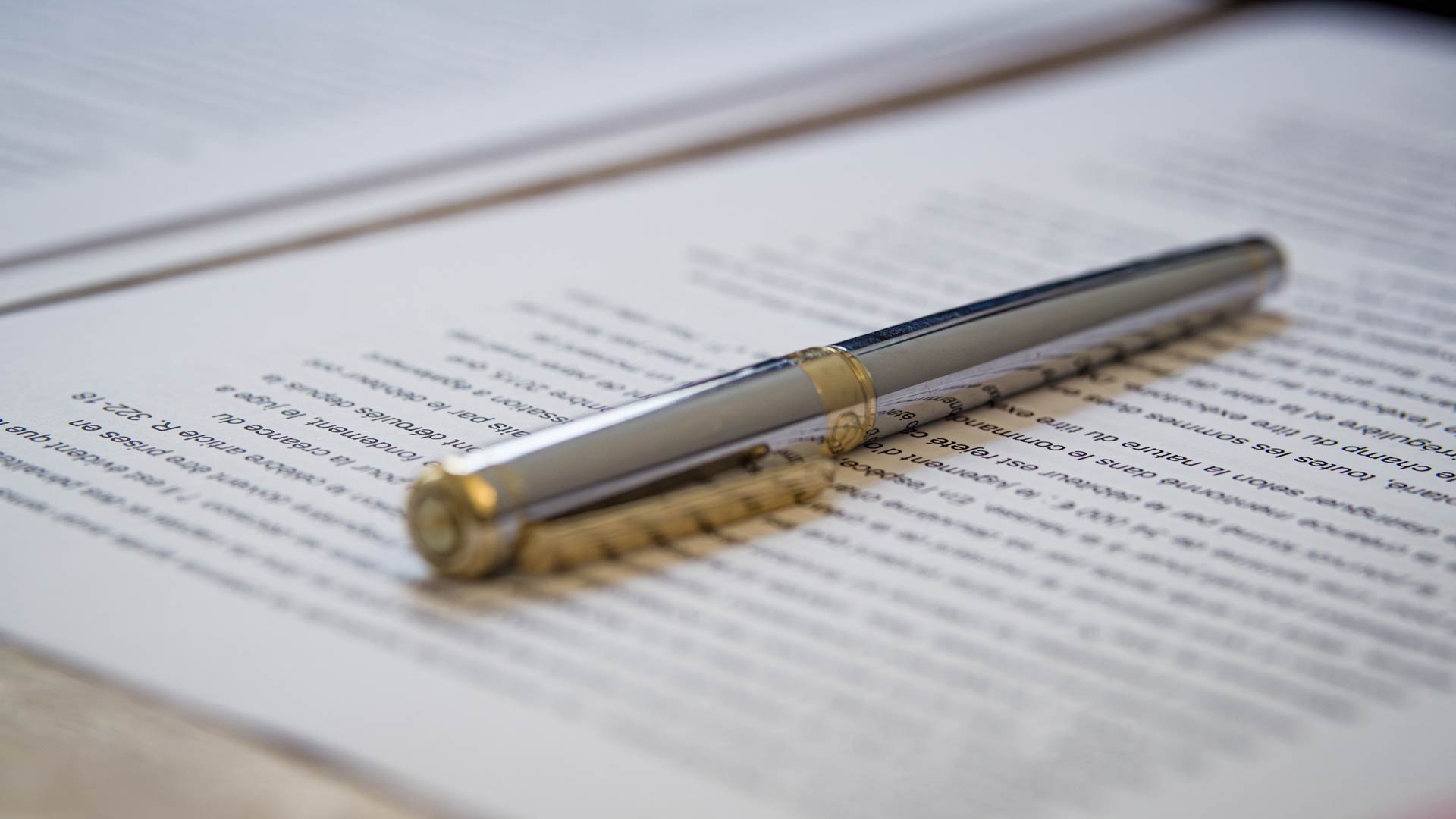 Focus sur la précision Stylo argenté et doré posé sur un document juridique
